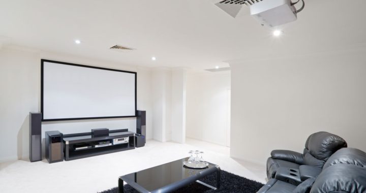 A sleek home theater room with a large screen, sound system, and comfortable seating, highlighting entertainment solutions.